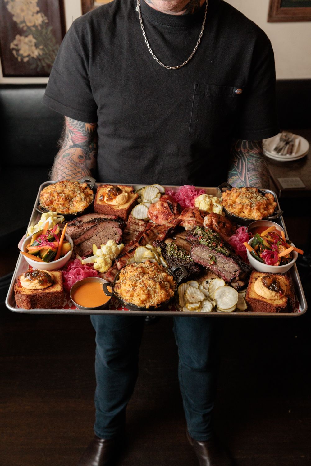 A staff member carrying the full Hank's Platter tray to the table