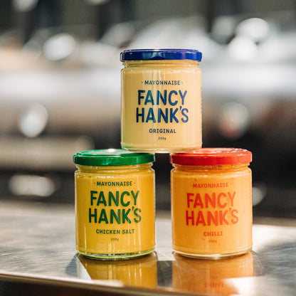 Three jars of Fancy Hank's mayonnaise sitting on a bench in the Fancy Hank's Restaurant kitchen